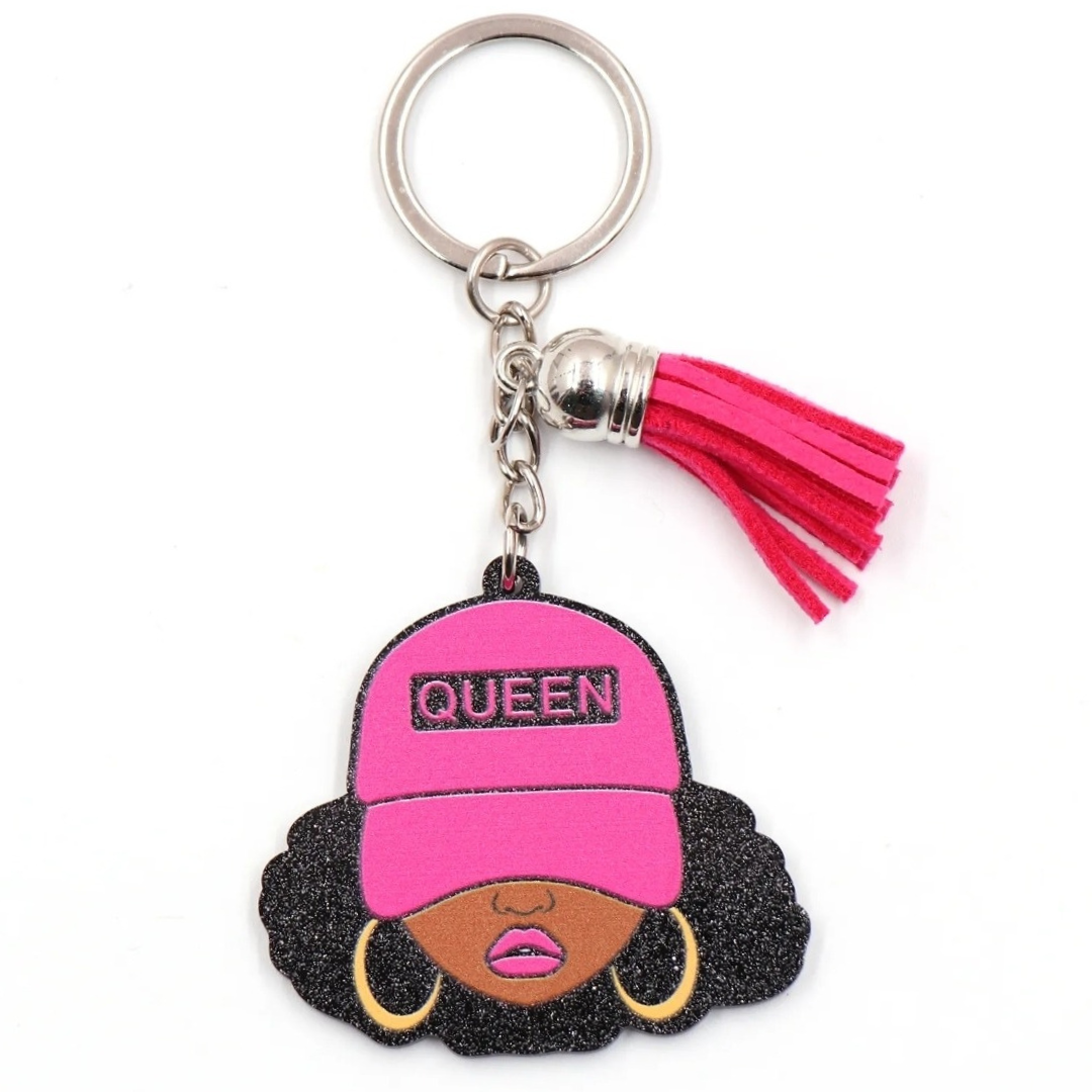 Keychain featuring a glittery illustration of a Black woman with curly hair, gold hoop earrings, and a hot pink cap labeled “QUEEN,” accented with a matching pink tassel and silver key ring.